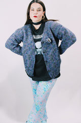 Women's vintage 1990's long sleeve acrylic knit button up cardigan in purple and blue colors with a flower pin.