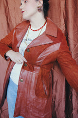 Women's vintage 1970's long sleeve button up burnt orange suede and leather jacket. Long length with matching belt.