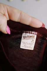 Men's or women's vintage 1970's Sportswear, Made in USA label maroon colored tee with white graphic on the front in a polyester and cotton material.