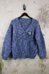 Women's vintage 1990's long sleeve acrylic knit button up cardigan in purple and blue colors with a flower pin.