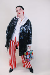 Women's vintage 1960's long sleeve black vinyl material jacket with gold buttons and hardware. Fully lined and has two side pockets.