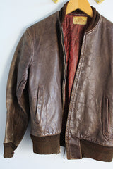 Men's or women's vintage 1950's Genuine Horsehides All Weather Garment, San Francisco, California label long sleeve brown leather bomber jacket with ribbed knit trim and quilted liner.