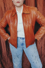 Women's or men's vintage 1970's Wilson label long sleeve burnt orange colored leather zip up jacket. Side pockets and dagger collar.