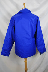 Men's or women's vintage 1980's Designer's Sportswear label long sleeve bright blue colored nylon material puffer jacket with side pockets.