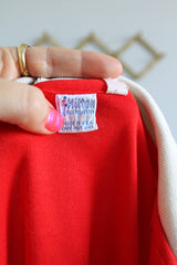 Women's vintage 1970's Hilton, Made in USA label short sleeve red half button closure polo bowling shirt with white striped collar and trim.