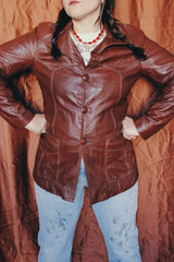 Women's or men's vintage 1970's chocolate brown colored leather jacket with leather buttons and double lapel.