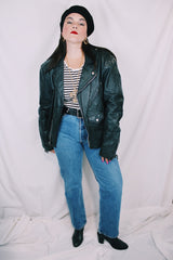 Men's or women's vintage 1980's long sleeve black leather moto jacket with all over silver hardware. Snap buttons, pockets with zippers, and zipper closure.