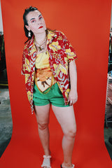 Women's or men's vintage 1970's Sundek, Made in USA label short sleeve button up shirt with dagger collar in cotton material with all over Hawaiian print in red, yellow, and green colors.