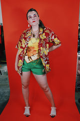Women's or men's vintage 1970's Sundek, Made in USA label short sleeve button up shirt with dagger collar in cotton material with all over Hawaiian print in red, yellow, and green colors.