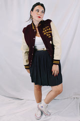 Women's or men's vintage 1982 Nelson's Jackets, Portland, Oregon label long sleeve letterman jacket with a maroon wool body and cream colored leather arms. Yellow stripped trim and popper buttons. Embroidery on chest.