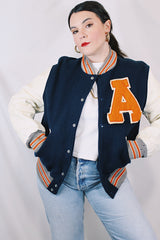 Men's vintage 1960's Skookum Letterman, Centralia Knitting Mills, Centralia Washington label long sleeve navy, white, and orange varsity letterman jacket in wool and leather material.