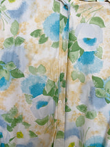 Women's vintage 1970's long sleeve button up blouse with collar in an overall yellow, green, and blue floral print. Acetate and Nylon blend material.