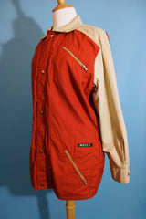 Women's or men's vintage 1980's Aspen label long sleeve zip up lightweight windbreaker jacket in tan and burn orange.