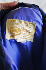 Women's or men's vintage 1970's Sears, Boys label sleeveless puffy vest in white, navy, and blue. Side pockets and zipper up the front.