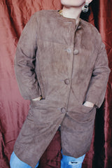 Women's vintage 1960's long length long sleeve tan brown colored suede jacket. No collar and suede buttons up the front.