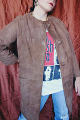 Women's vintage 1960's long length long sleeve tan brown colored suede jacket. No collar and suede buttons up the front.