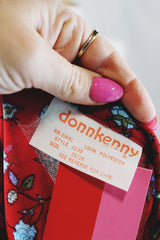 Women's vintage 1970's Donnkenny label long sleeve button up blouse with an attached tie neck. Red with all over blue ditsy floral print.