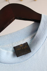 Men's or women's vintage 1980's Touch of Gold, Made in USA label long sleeve light blue t-shirt with red text on front that reads Texas in a polyester and cotton material.