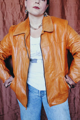 Women's or men's vintage 1970's Adler Leather MFG. CO., Made in California label long sleeve burnt orange leather jacket that zips up the front with side pockets and dagger collar.