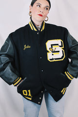 Men's or women's vintage 2000's Settlemein's, Portland, Oregon label long sleeve black varsity letterman jacket with yellow trim.