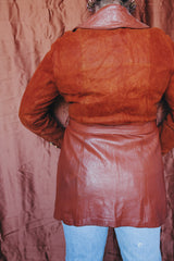 Women's vintage 1970's long sleeve button up burnt orange suede and leather jacket. Long length with matching belt.