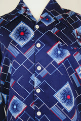 Men's vintage 1970's Da Vinci Presents Delfina label long sleeve vibrant navy blue button up shirt with all over white and red abstract print in thick polyester material.