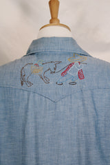 Men's vintage 1970's long sleeve chambray denim shirt with colored embroidery in the front and back.