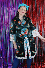 Women's vintage 1970's Bai Hua, Made in China label 3/4 arm length mid length lightweight robe jacket in black, white, blue, and an all over floral embroidered print.