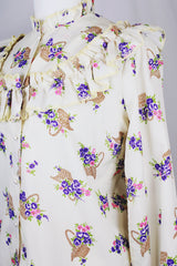 Women's vintage 1980's Val Lanne's label long sleeve button up blouse with ruffle details and pearl buttons. Cream color with all over purple floral print.