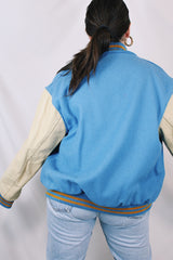 Men's or women's vintage 1994 Settlemien's, Portland, Oregon label long sleeve baby blue and cream varsity letterman jacket with yellow trim in leather and wool material.
