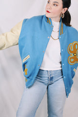 Men's or women's vintage 1994 Settlemien's, Portland, Oregon label long sleeve baby blue and cream varsity letterman jacket with yellow trim in leather and wool material.