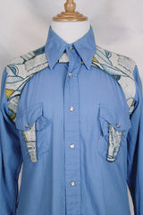 Men's vintage 1970's long sleeve button up blue colored shirt with patchwork detail throughout. Pearl snapper buttons up the front.