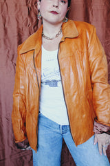 Women's or men's vintage 1970's Adler Leather MFG. CO., Made in California label long sleeve burnt orange leather jacket that zips up the front with side pockets and dagger collar.