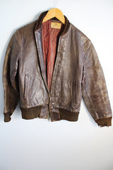 Men's or women's vintage 1950's Genuine Horsehides All Weather Garment, San Francisco, California label long sleeve brown leather bomber jacket with ribbed knit trim and quilted liner.