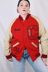 Men's vintage 1987 Nelson's Jackets, Portland, Oregon label long sleeve cream and red colored varsity letterman jacket in wool and nylon material. Has patches and pins.
