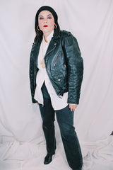 Men's or women's vintage 1980's long sleeve black leather motorcycle jacket with silver hardware. Zipper front closure and pockets.