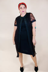 Women's vintage 1960's short sleeve mini length black dress with lace overlay and ribbon trim and bow. Zipper in the back.