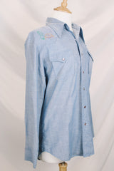 Men's vintage 1970's long sleeve chambray denim shirt with colored embroidery in the front and back.