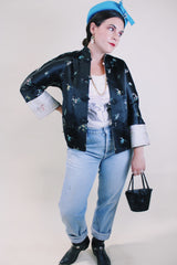 Women's vintage 1960's satin reversible robe jacket in black and grey with all over embroidered print. Mandarin collar and fabric buttons.