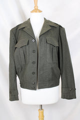 Women's or men's vintage cropped army jacket in a dark green grey wool material. Has a button closure and two front chest pockets.