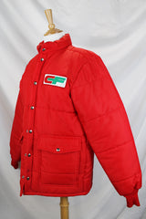 Women's or men's vintage 1980's Tonkin Wearables, Woodinville, WA, Made in USA label long sleeve bright red nylon puffer jacker with patch on left chest and a zipper and popper buttons closure.
