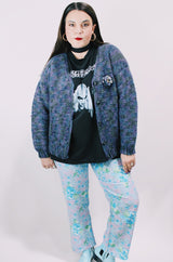 Women's vintage 1990's long sleeve acrylic knit button up cardigan in purple and blue colors with a flower pin.