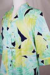 Women's vintage 1970's long sleeve button up tunic blouse with all over green and navy floral print. Flared sleeved and fabric covered buttons.