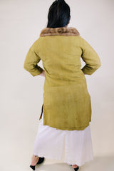 Women's vintage 1960's long sleeve long length button up suede coat with fur trim on collar. Mustard yellow color. Has pockets and side slits.