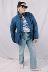 Men's or women's vintage 1980's long sleeve navy blue puffer jacket with zipper, popper buttons, and pockets. Cotton and polyester materials.