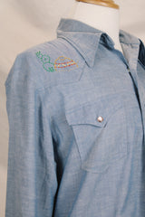 Men's vintage 1970's long sleeve chambray denim shirt with colored embroidery in the front and back.
