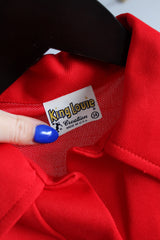 Women's vintage 1970's King Louie Creation, Made in USA label short sleeve red bowling top with half button closure, collar, and a pocket in polyester.