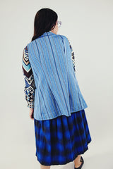 1970's vintage light blue best with no closure and two front pockets and striped pattern throughout back
