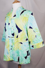 Women's vintage 1970's long sleeve button up tunic blouse with all over green and navy floral print. Flared sleeved and fabric covered buttons.