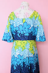 Women's vintage 1970's Sears Hawaiian Fashions label short sleeve maxi length cotton material Hawaiian print dress in green, blue, and white print with a square neckline.